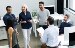 Beraterin bespricht sich in einem Büro mit jungen Teammitgliedern 